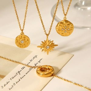 Detail of 18K gold-plated titanium steel necklaces with sunburst and hammered coin pendants