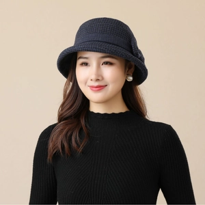 Elegant navy blue houndstooth bucket hat for women worn by a model against a beige backdrop