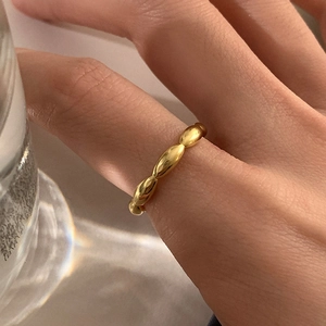 Primer plano de un anillo de cuentas dorado con textura metálica pulida al dedo