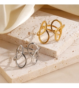 Close-up of gold and silver geometric open rings on silk fabric and travertine stone