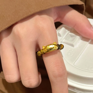 Detail of tiger eye bead ring featuring a golden cat charm and elastic band design