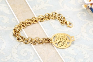 Detail of gold double-layered chunky chain bracelet with a polished Hamsa palm charm