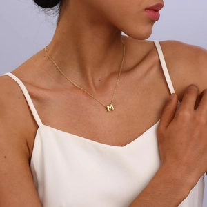 Detailed view of bubble 3D letter M pendant necklace in 18k gold plated finish