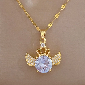 Macro detail of gold crown wing pendant with a sparkling central crystal and cubic zirconia