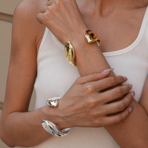 Close-up of gold and silver irregular organic metal bangles with high-shine mirror polish