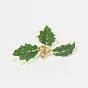 Close-up of artificial Christmas holly leaves with golden berries and white-edged leaves