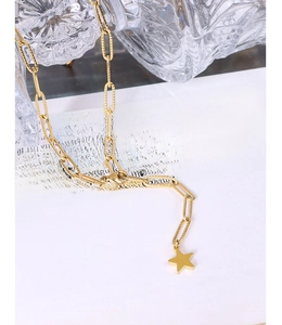 Macro detail of 18K gold paperclip chain necklace with textured links and star pendant