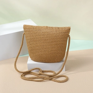 Macro detail of the natural woven straw texture and artisan craftsmanship on a summer crossbody bag