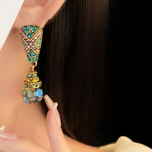 Close-up of vintage drop earrings with colorful rhinestones and transparent crystal pendant