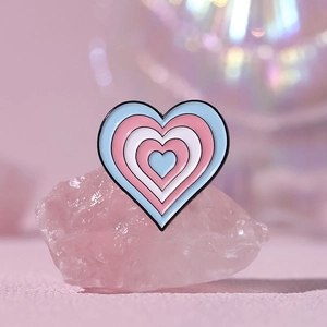 Cute pink heart enamel pin with rainbow colors and layered metal design on crystal base