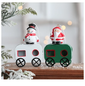 Detailed view of hand-painted iron Christmas train ornaments with Santa and Snowman figures