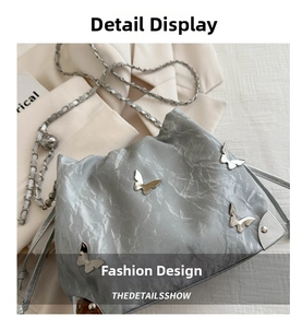 Detail of silver drawstring bag with metal butterfly charms and rivet decorations