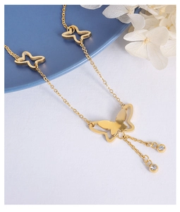 Detail of gold butterfly pendant anklet with sparkling crystal droplets and refined chain