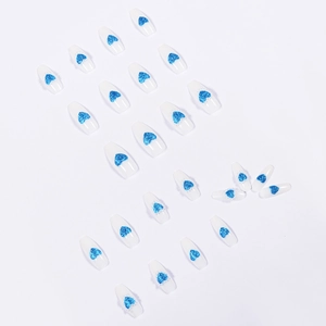 Blue glitter heart and pearl press-on nails in long coffin shape on white background