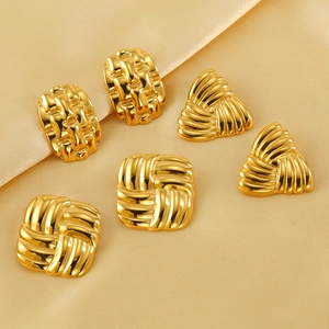 Detail of vintage 18k gold plated geometric earrings with textured woven surface on silk