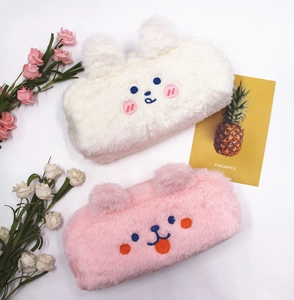 Close-up of soft plush pencil cases with cute embroidered bear faces in pink and white