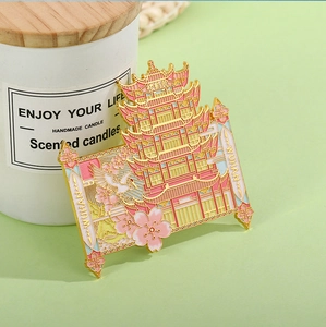 Detailed close-up of a Wuhan Yellow Crane Tower metal enamel badge with cherry blossoms