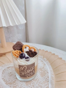 Close-up of handmade strawberry chocolate candle with mini cookies and blueberry decor