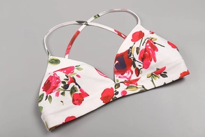 Détail du haut de bikini blanc avec imprimé fleurs roses rouges et texture tricotée