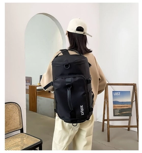 Detail of a large black cylinder backpack featuring waterproof fabric and side brand logo