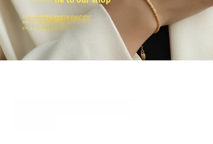 Detail of 18K gold-plated twisted rope bracelet with adjustable chain on white suit background