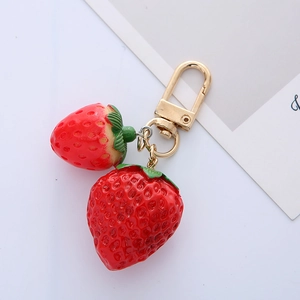 Realistic 3D red strawberry keychain detail with polished gold metal hardware