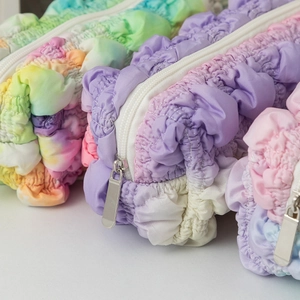 Detail van kleurrijk gegolfd etui met getextureerde macaron-stof en zilveren ritssluiting