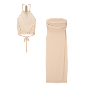 Flat lay view of a nude two-piece set featuring a halter crop top and side slit maxi skirt