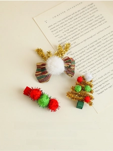 Lot de trois barrettes de Noël avec bois de renne et sapin posés sur un papier vintage