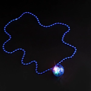 Macro shot of 70s glowing disco ball pendant with blue beaded chain on black background