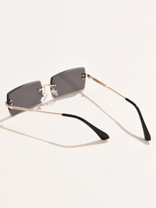 Detail of rimless rectangle sunglasses with grey gradient lenses and gold metal temples