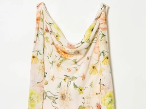 Détail en gros plan du tissu en mousseline crème avec des motifs floraux jaunes et roses