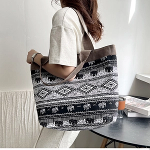 Close-up of black and white bohemian canvas tote bag with elephant and geometric patterns