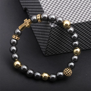 Detail of beaded men's bracelet with hematite beads and a gold cross pendant charm