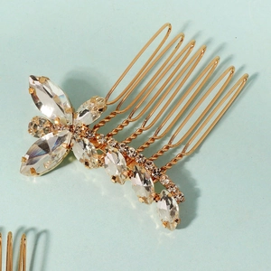 Dettaglio del pettine per capelli dorato da sposa con strass lucidi su fondo blu