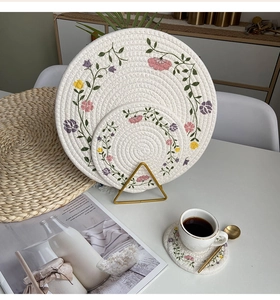 Three-piece set of woven cotton rope coasters with floral embroidery detail