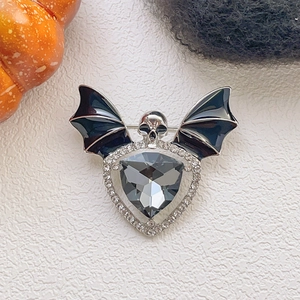 Macro d'une broche chauve-souris gothique avec crâne, pierre grise et cristaux fins
