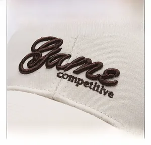 Detailed macro view of 3D letter embroidery on a beige cotton baseball cap surface