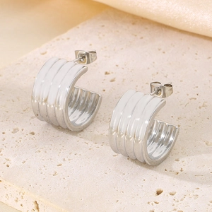 Détail macro de boucles d'oreilles C argentées avec rayures blanches sur pierre