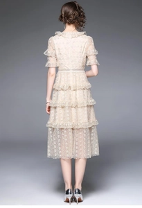 Vue de dos d'une robe élégante en dentelle champagne avec jupe à volants et manches