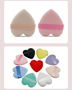 Detailed view of heart-shaped makeup sponges in multiple colors with satin ribbon handles