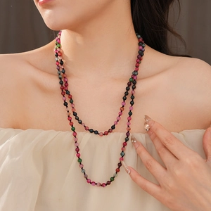 Detail of bohemian multilayer beaded necklace with red green and blue agate round beads