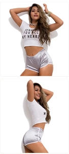 Detail of white crop top with 'SENDING YOU ALL MY HEART' text and silver satin shorts