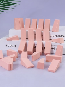 Macro shot of pink wedge-shaped non-latex makeup sponges piled on a display stand