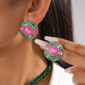 Détail de boucles d'oreilles bohèmes rondes avec mosaïque de cristaux rose et vert