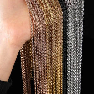 Close-up of twisted rope chains in gold, rose gold and silver finishes on hand