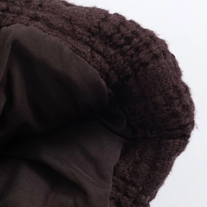Dettaglio macro della trama in maglia marrone scuro e fodera interna per comfort e calore
