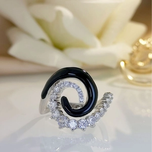 Elegant silver spiral ring with black enamel and sparkling zircon on white roses