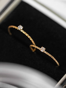 Luxurious hammered titanium steel ring set with sparkling small diamonds in gold finish
