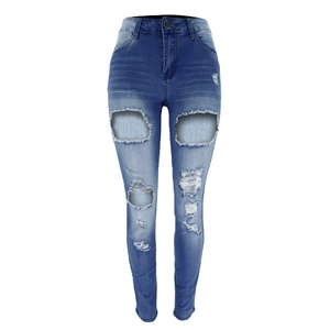 Close-up of distressed ripped details and washed texture on high waist denim jeans